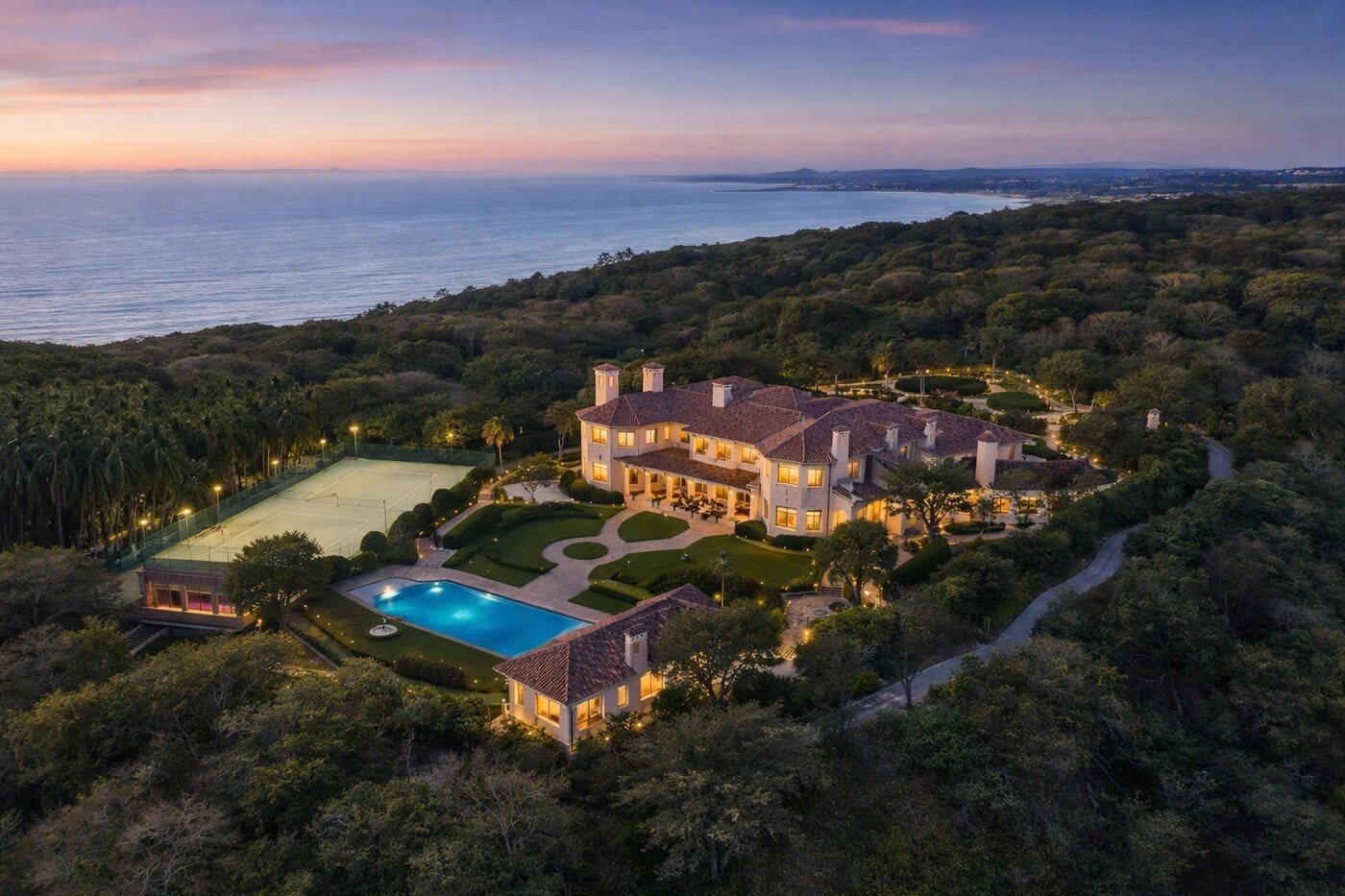 Residencia con alberca y cancha rodeada de selva junto al mar, al atardecer